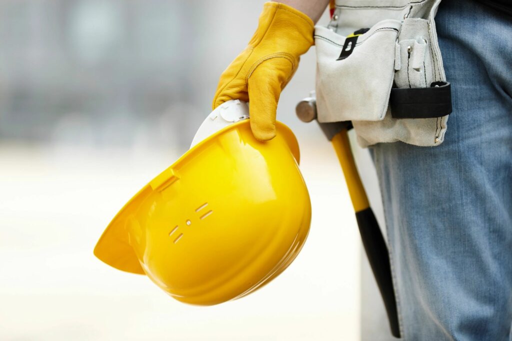 A man is holding his yellow construction cap