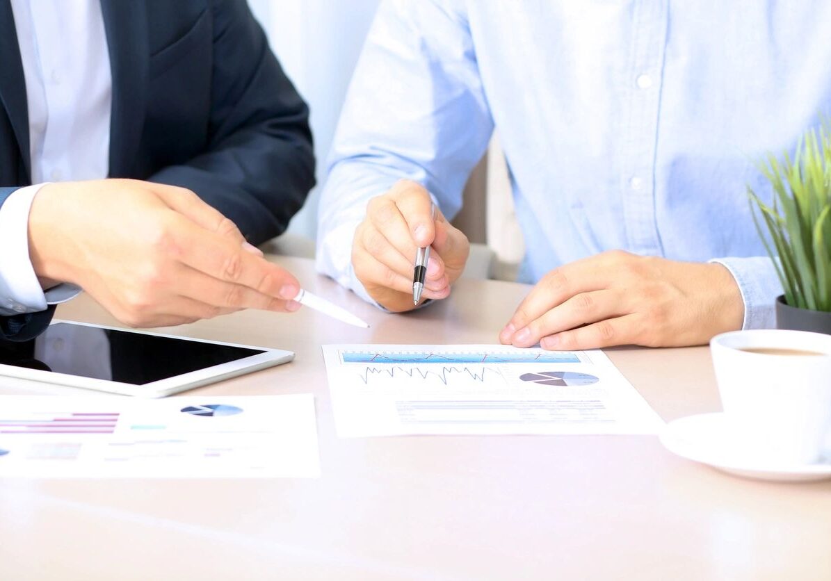 Two businessmen analyzing financial charts.